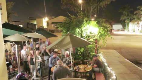 time lapse of patrons outside a restaurant at night