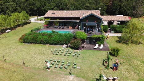 slow orbiting shot of people setting up a wedding ceremony seating at a villa