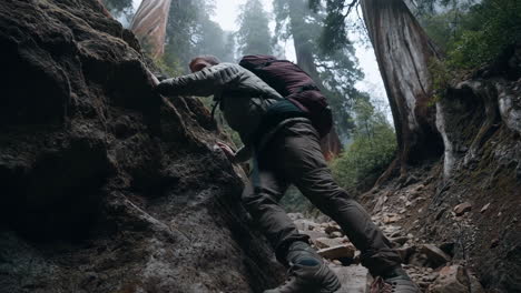 man hiking a rocky trail in a misty forest