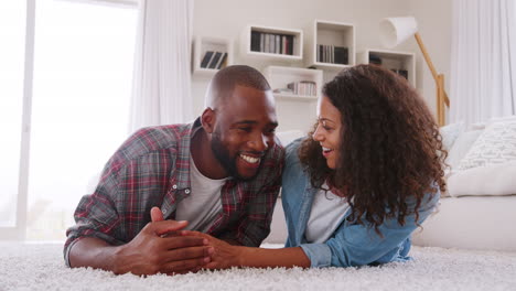 portrait of couple lying on rug in lounge at home shot in slow motion