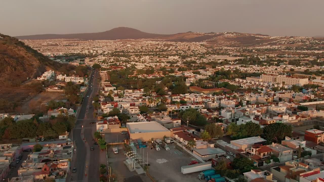 Querétaro, Bajío, Messico - Quartieri estesi e strade tortuose si snodano attraverso la valle, con colline che si ergono sullo sfondo - Drone in volo in avanti.