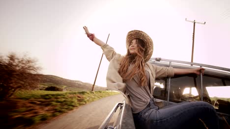 beautiful woman sitting with outstretched arms in a pick-up truck