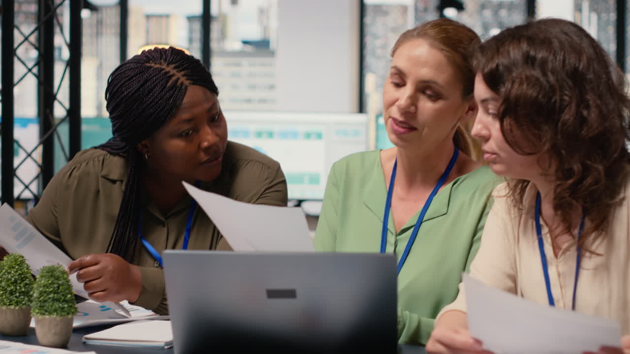 Vertical Video Businesswomen compare analytics and plan strategy in a modern workspace