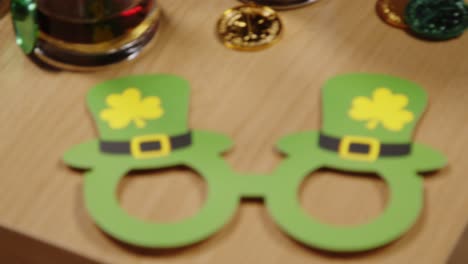 close up of irish novelties and props including gold coins and glasses celebrating at st patrick's day party