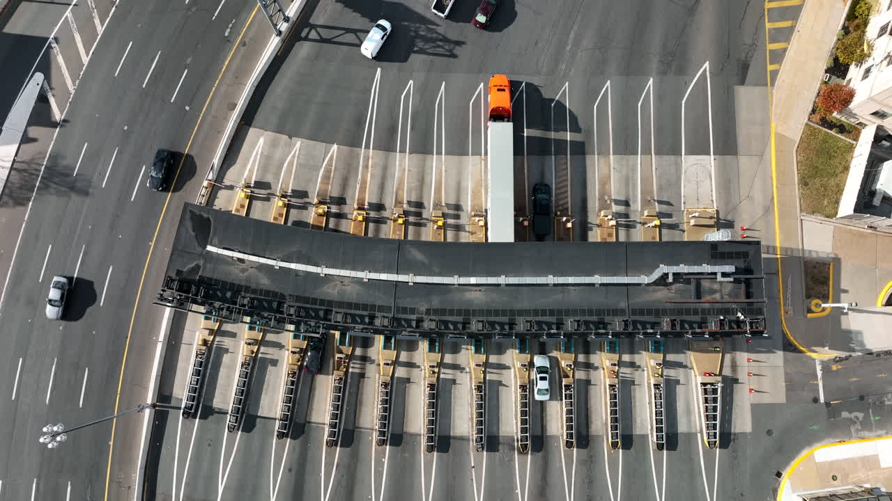 съемка сверху вниз транспортного потока, проходящего через кабинку для оплаты проезда по платным дорогам, чтобы заплатить деньги электронным способом