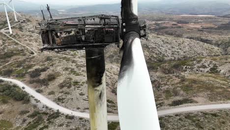 extremo primer plano aéreo giratorio de una turbina eólica destruida por un incendio en un paisaje árido en se españa