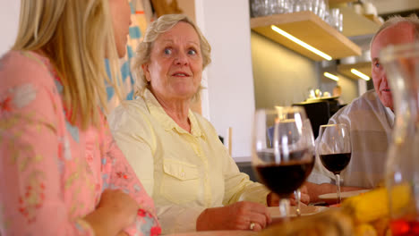 side view of caucasian mother talking with her daughter at dining tablet in a comfortable home 4k