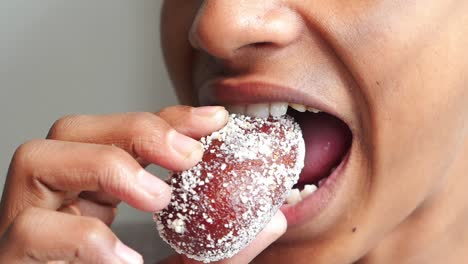 una persona comiendo un gulab jamun