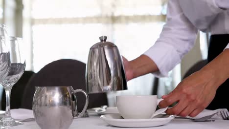 la camarera vierte el té.