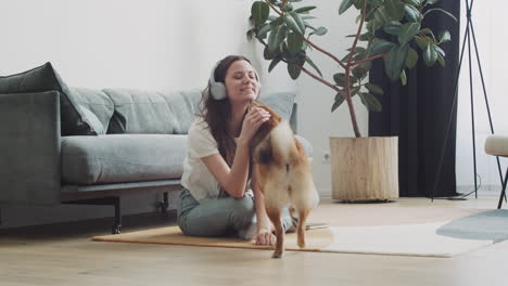 Young-Woman-Calls-Her-Dog-To-Feed-Him-While-Working-On-Her-Laptop-At-Home