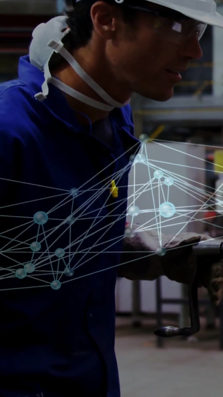 Factory worker using tool while camera tracking right, overlay hovering in front showing quality