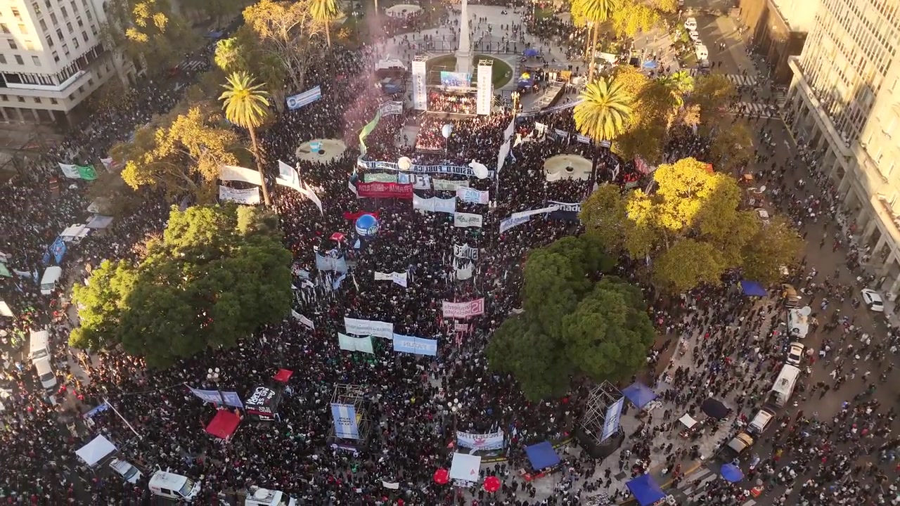 Vista drone di una grande folla di manifestanti con striscioni a sostegno dell'istruzione pubblica in Plaza de Mayo, Buenos Aires, Argentina.