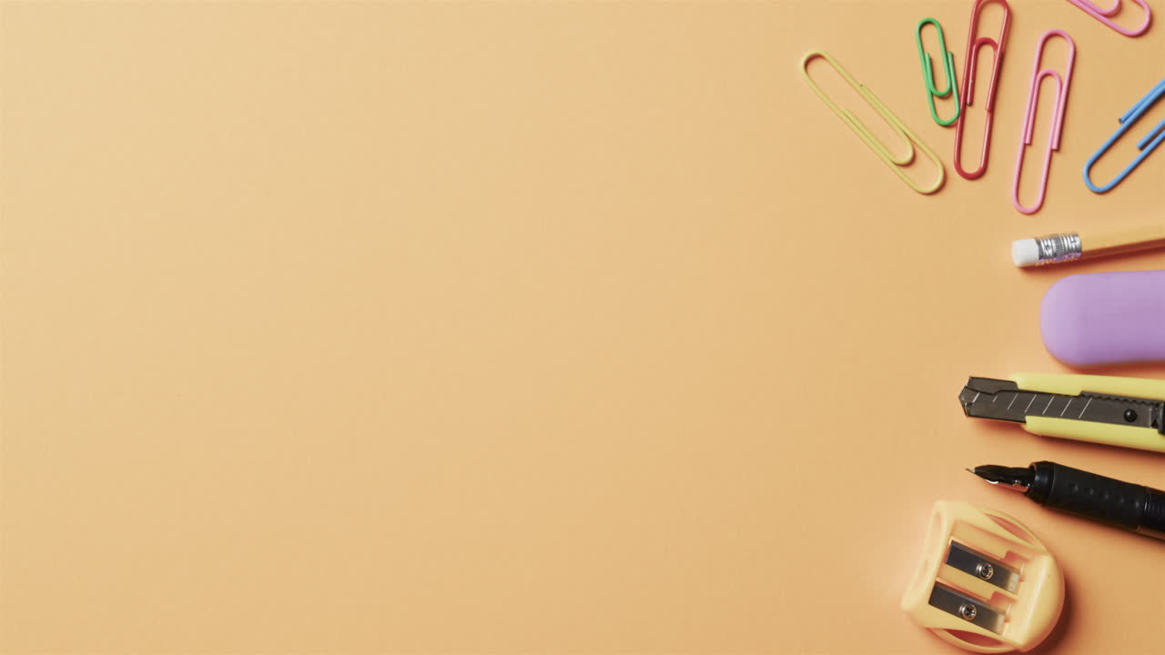 슬로우 모션으로 베이지색 배경에 복사 공간이 있는 다채로운 학교 서류의 상상