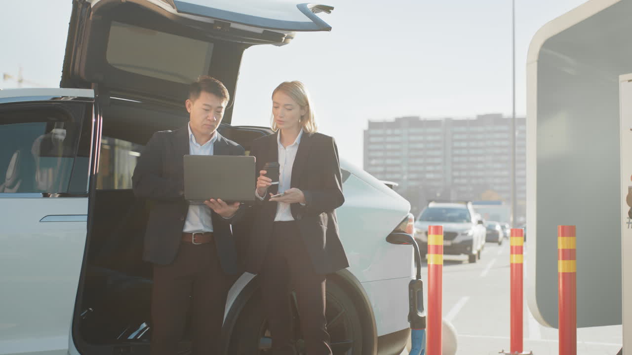 gente de negocios discutiendo en la estación de carga de vehículos eléctricos