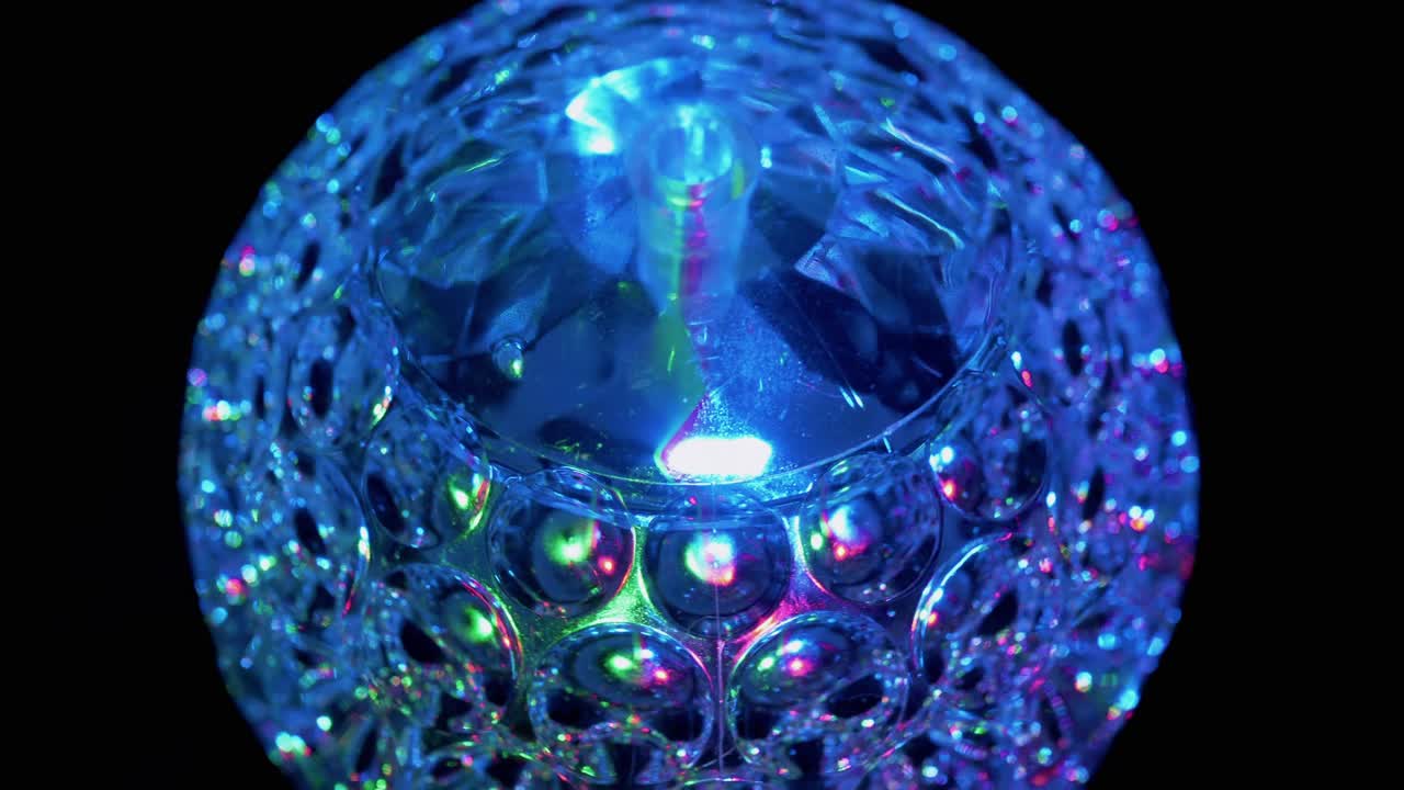 회전하는 디스코 공, 어두운 곳에서 빛나는 네온 불빛, 클로즈업.