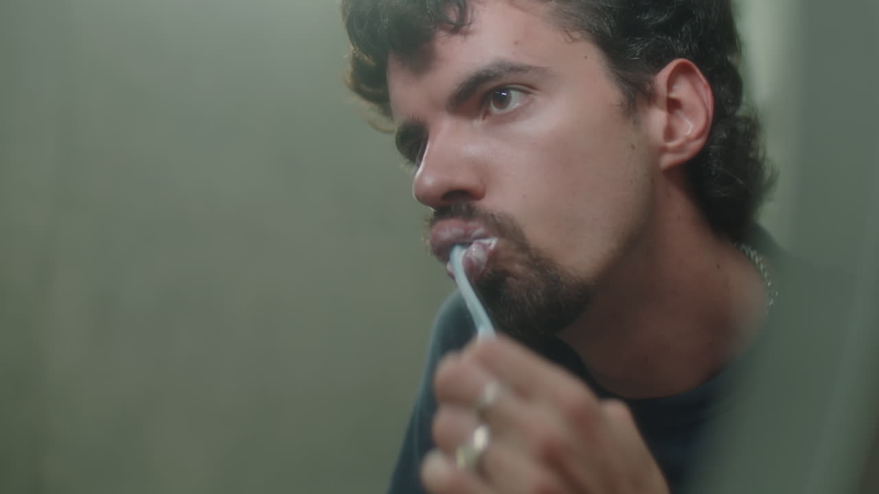 Mirror Reflection of Man Brushing Teeth