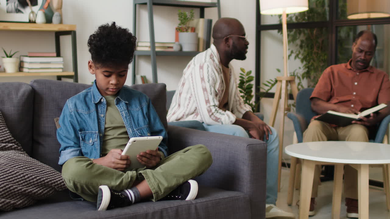 Black kid playing with tablet at home