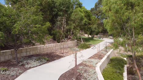 Footpath with trees either side leading to seat and a child&rsquo;s play area