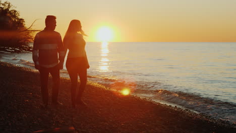 Paar-Geht-Bei-Sonnenuntergang-Am-Strand-Spazieren