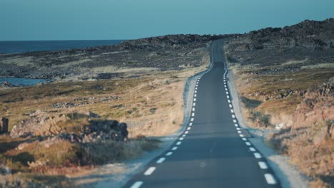 conduciendo por la estrecha carretera a lo largo de la costa de varanger