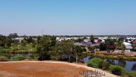 panorámica aérea desde el campo de trigo seco hasta los humedales suburbanos