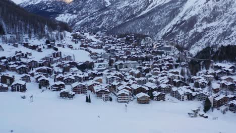 Luftaufnahme-Einer-Wunderschönen-Kleinen,-Schneebedeckten-Stadt-In-Den-Bergen