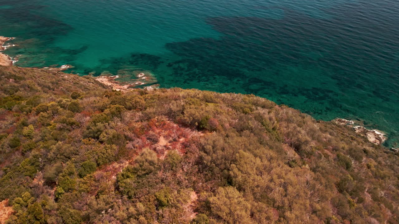 vista aérea del océano tropical azul más allá de la montaña en cerdeña, italia - toma aérea de drones