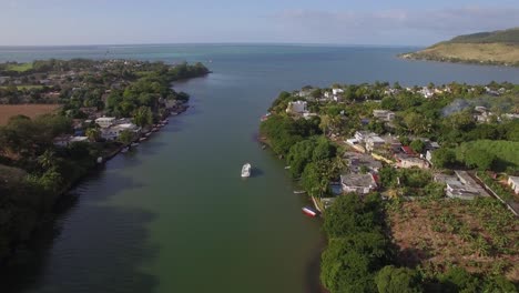 Mauritius-coastal-town-and-river-falling-into-ocean-aerial-view