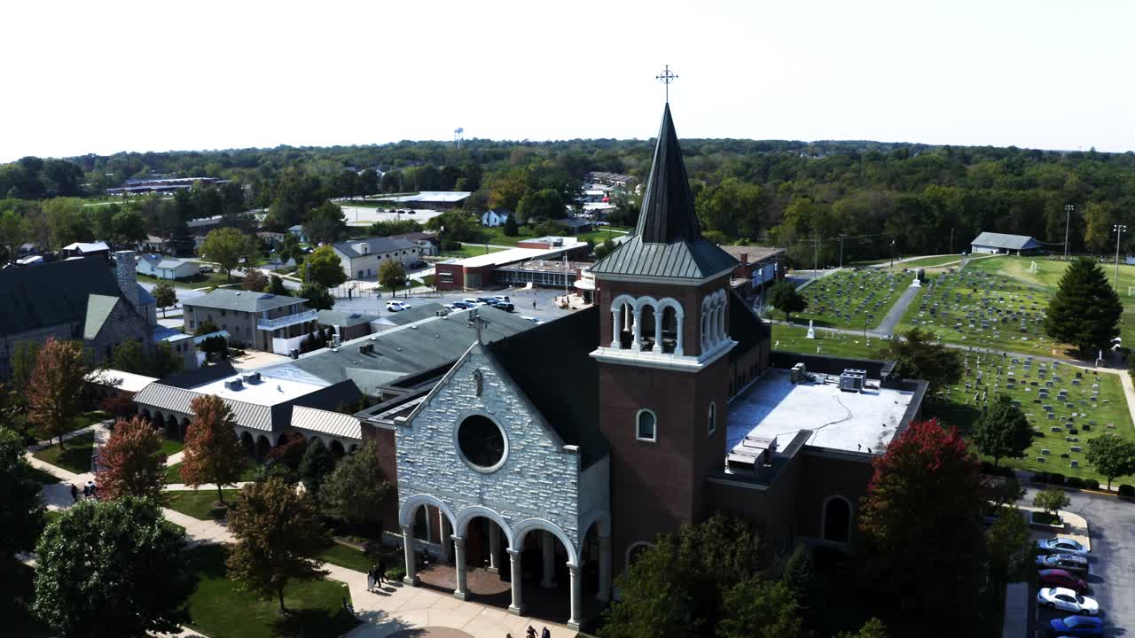 A serene view of a church with a cemetery behind it, overlooking a nearby roadway, blending historic architecture, quiet memorial grounds, and modern infrastructure in a peaceful setting.