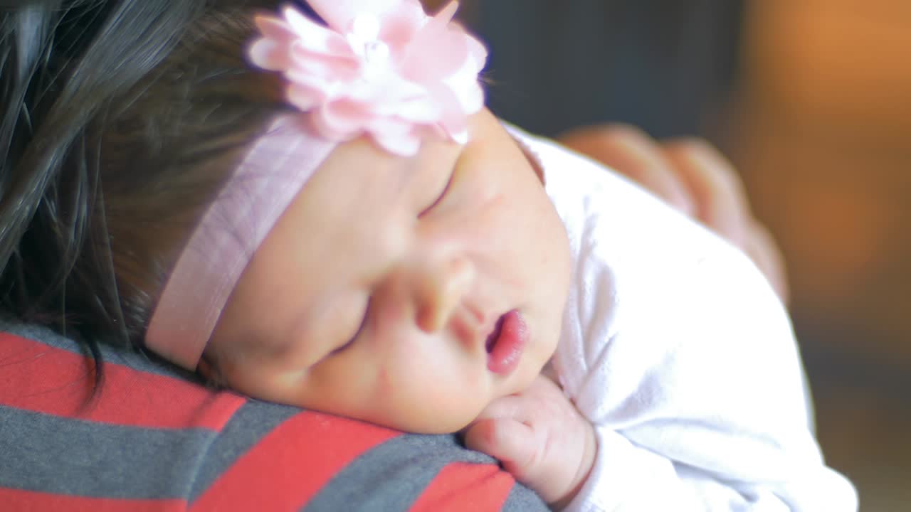 잠자는 신생아를 어깨에 고 있는 어머니의 어깨 풍경