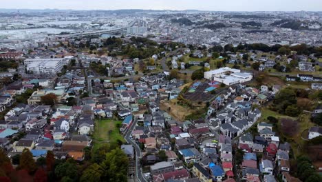 Una-Densa-Y-Colorida-Zona-Residencial-Con-Un-Cielo-Nublado-Como-Telón-De-Fondo,-Un-Toque-De-Otoño,-Vista-Aérea