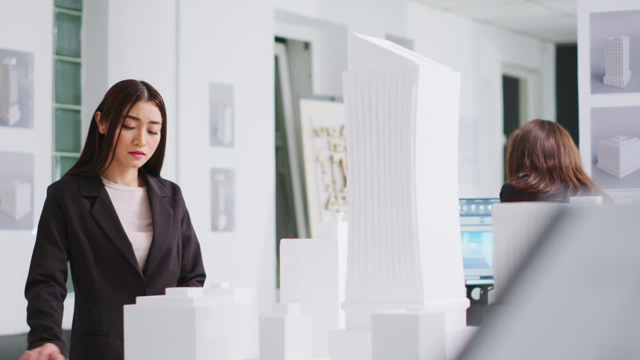 아키텍트가 블루프린트와 3d 빌딩 모델을 분석합니다.