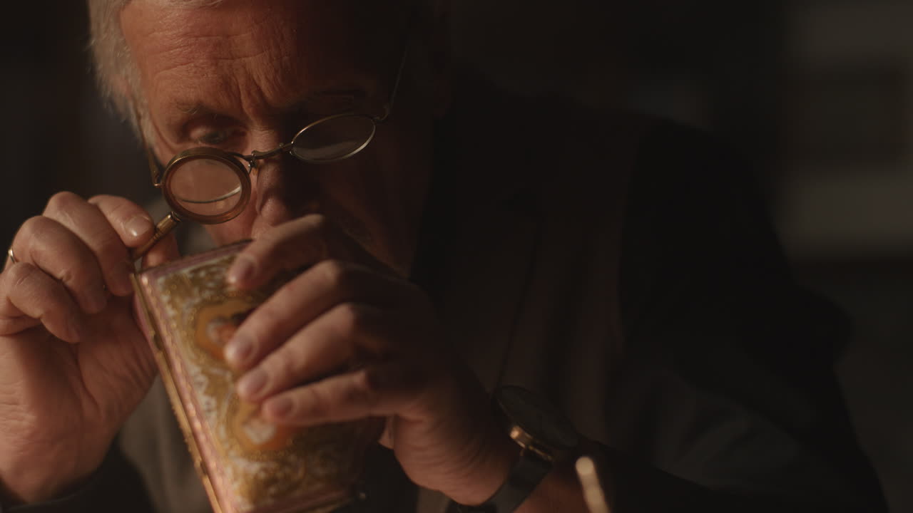 Older passionate man evaluates an old porcelain box