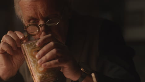 older passionate man evaluates an old porcelain box