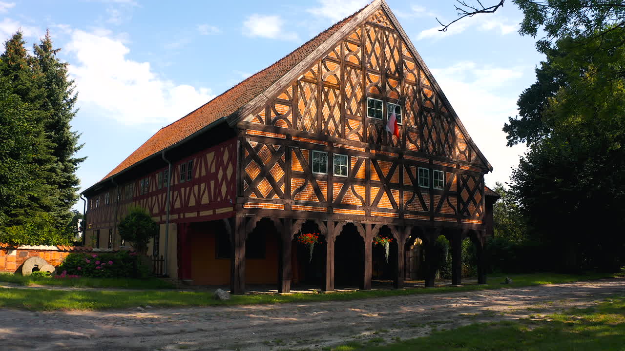 Aerial shot of drone flying to Charming Mennonite arcade house in Poland's historic town, a glimpse of timeless architecture