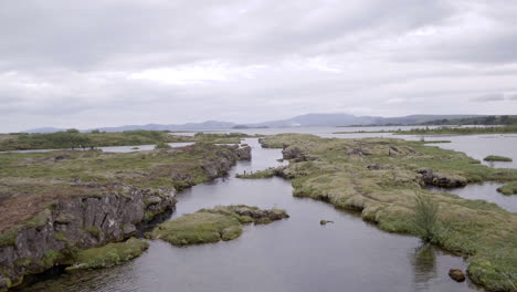 silfra snorkeling pond in iceland aerial push in over the water