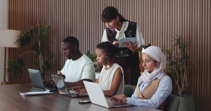 Diverse Team Collaborating on Laptops in Modern Office Workspace