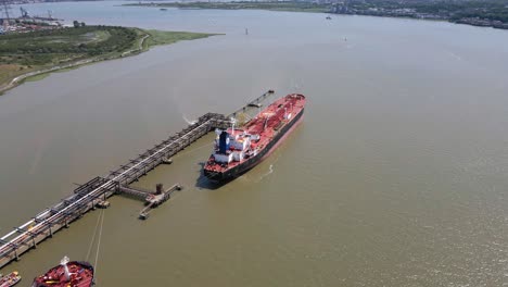 Industrial-Ship-at-Loading-Dock-Boat-Harbor,-Aerial-Orbit-Establishing