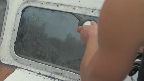 Applying-sika-flex-mastic-sealant-on-bow-windows-of-wooden-boat-using-sealant-gun