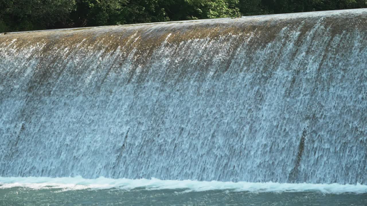Whitewater flows over a dam with a rapid speed