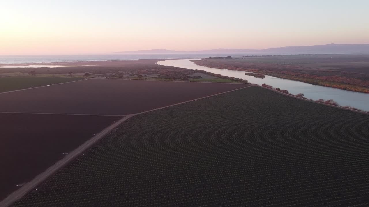 Salinas River turn near Castroville surrounded by vast agriculture farmland, aerial drone view
