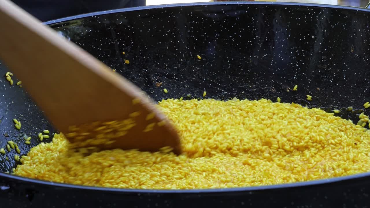 Sprinkling salt while stirring yellow Italian Risotto