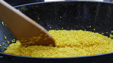 Sprinkling-salt-while-stirring-yellow-Italian-Risotto