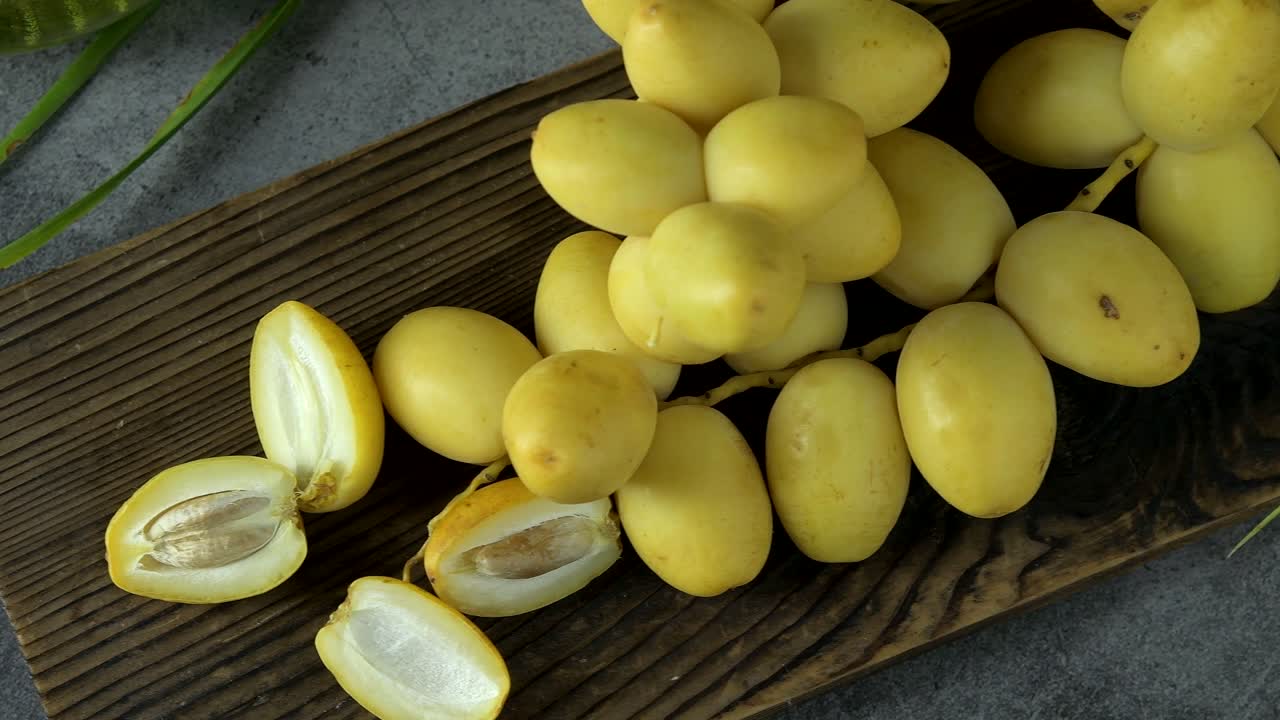 las palmeras de dátiles frescas se colocan en la mesa con aceite, concepto de alimentos saludables. palmeras de dátils. frutas crudas de palmieras de dátiles (phoenix dactylifera)