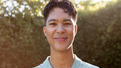 smiling young man outdoors, enjoying sunny day in casual attire
