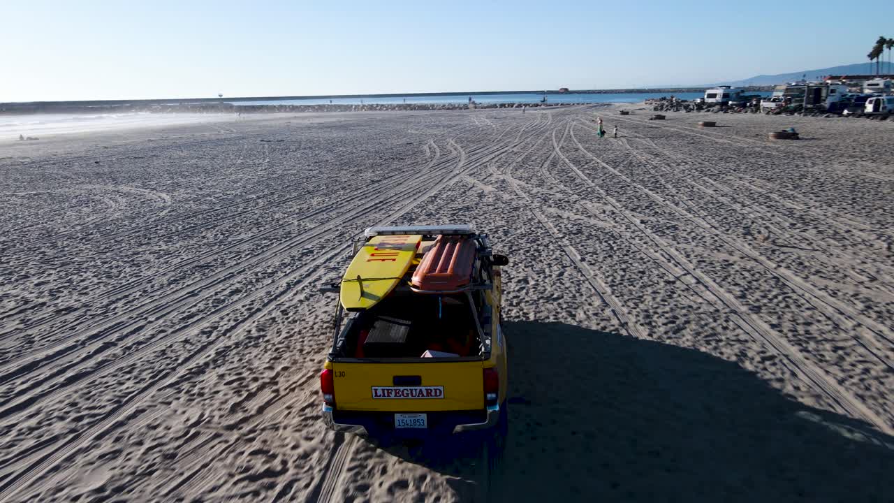 socorristas junto al mar conduciendo por la playa, vista aérea, puerto junto al mar