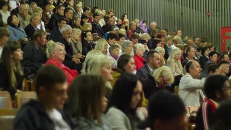 crowd of people to sitting and listening in a large hall