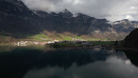 Aerial-Shot-Of-Rocky-Mountains-And-Clouds-On-Walensee-Unterterzen-Lake-Surface-In-Switzerland