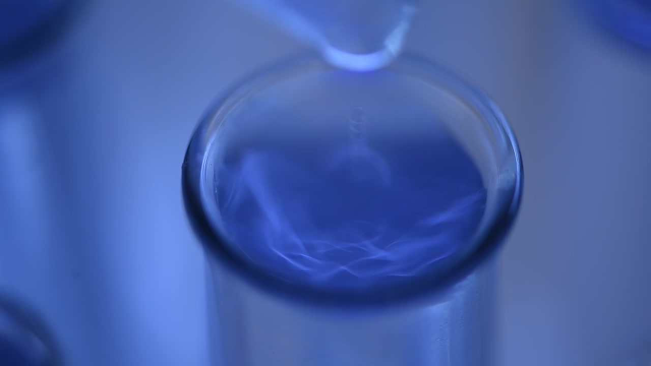 Close-up of Dropper Adding Liquid to Blue Solution in Test Tube