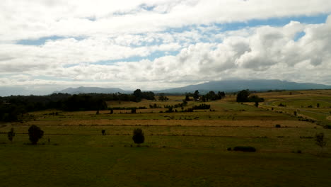 agricultural fields near puerto varas, vast rural landscape, cloudy sky, southern chile countryside. aerial forward